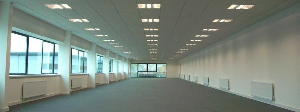 Veľká prázdna kancelárska miestnosť so šedým kobercom obložená protipožiarnymi doskami Promat