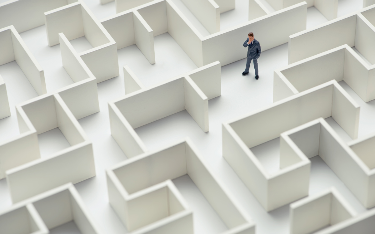 An image of a businessman navigating through a maze. Top view.