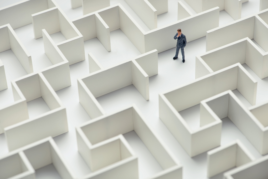 An image of a businessman navigating through a maze. Top view.