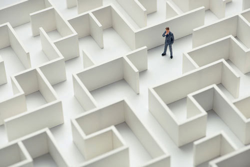 An image of a businessman navigating through a maze. Top view