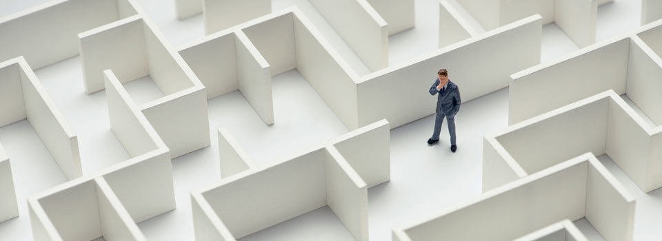An image of a businessman navigating through a maze. Top view.