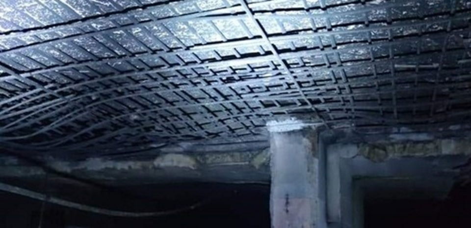 O imagine a unui tavan din beton armat crăpat în urma unui incendiu într-un garaj subteran.