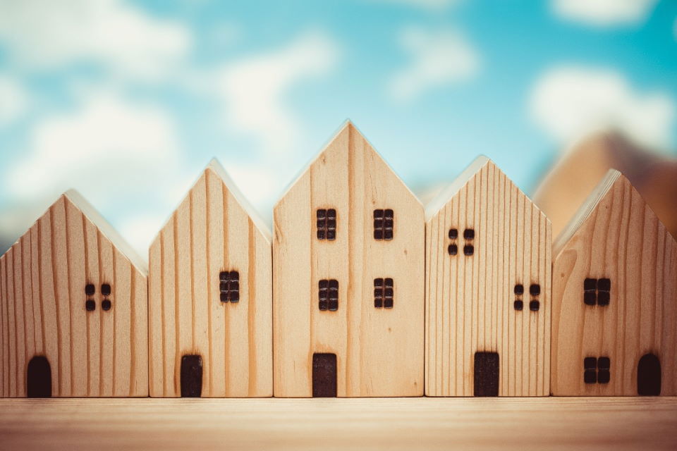 Komadi drva prikazani na način koji podsjeća na stambene zgrade u nizu – ilustracija drvene konstrucije.