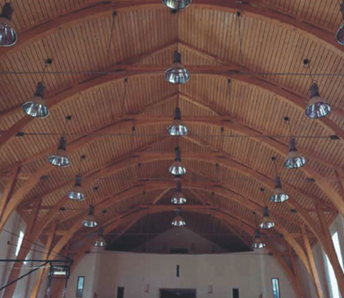 A view from below of a Gothic-looking wooden ceiling supported by wooden load-bearing elements.