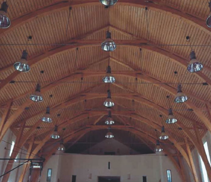 Pohľad zdola na drevený strop v gotickom štýle podopretý drevenou nosnou konštrukciou, ktorú chráni priehľadný protipožiarny náter na drevo