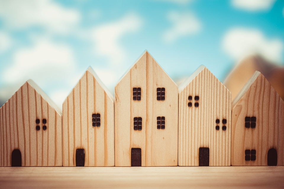 An image of a wooden fence unprotected from fire and charred in a way that reminds of a row of residential buildings.