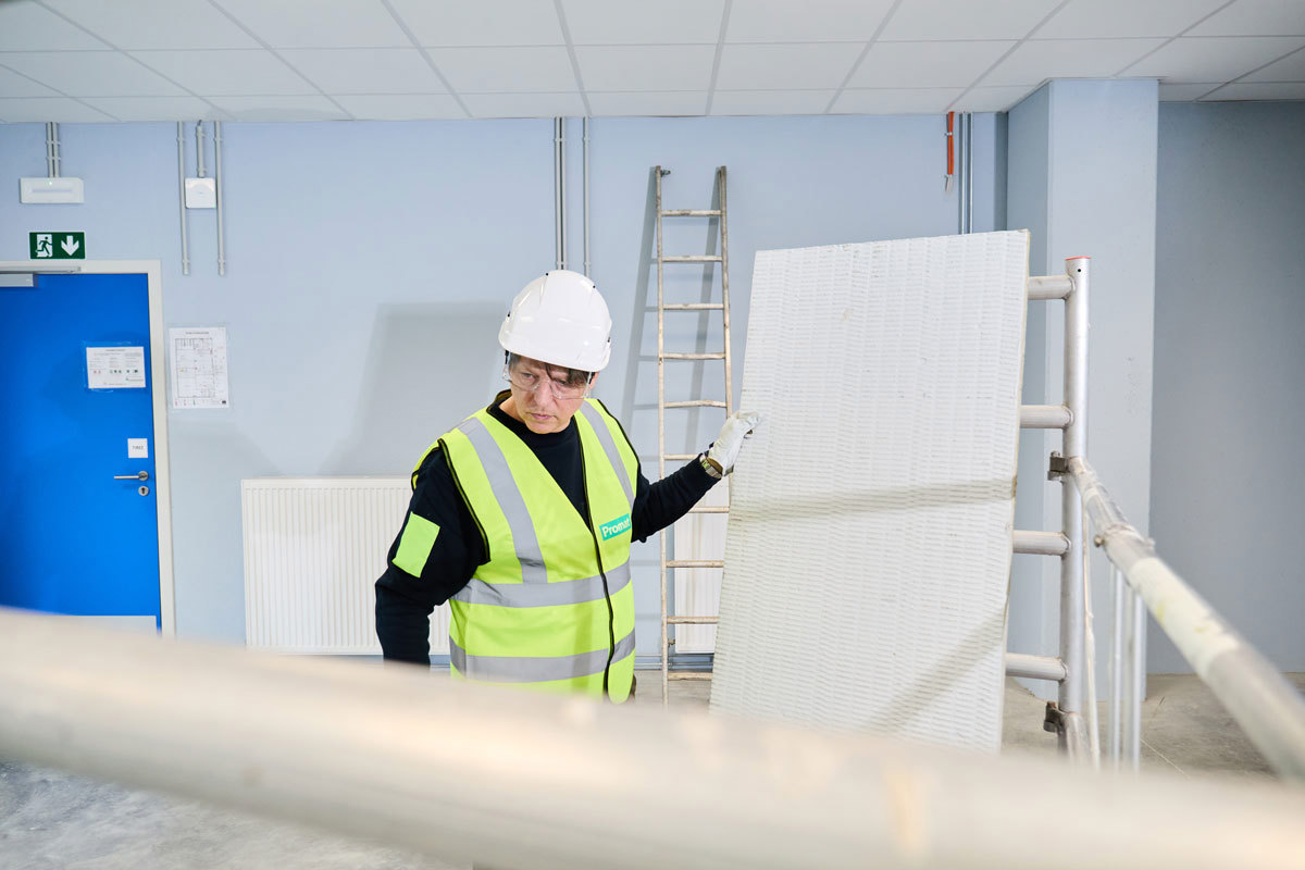 An installer holding a pre-coated mineral wool board with PROMASTOP®-CC .