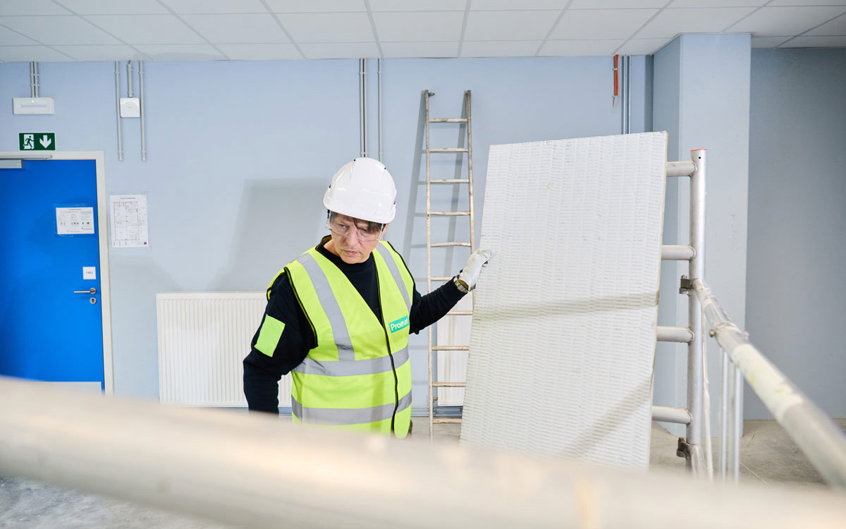 An installer holding a pre-coated mineral wool board with PROMASTOP®-CC .