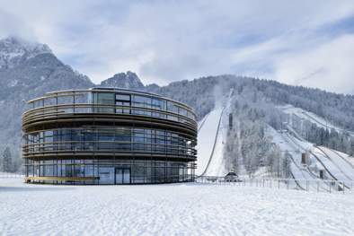 central building of Planica Nordic Center overlooking the ski jumping hills