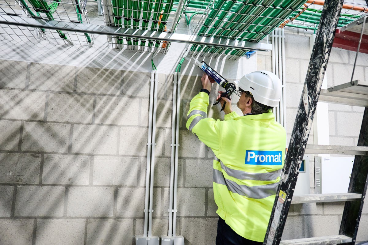 Człowiek pracujący w przestrzeni między materiałem przepustowym a wewnętrzną krawędzią otworu przepustowego
