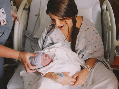 Imagine cu o mamă ținând în brațe un nou născut