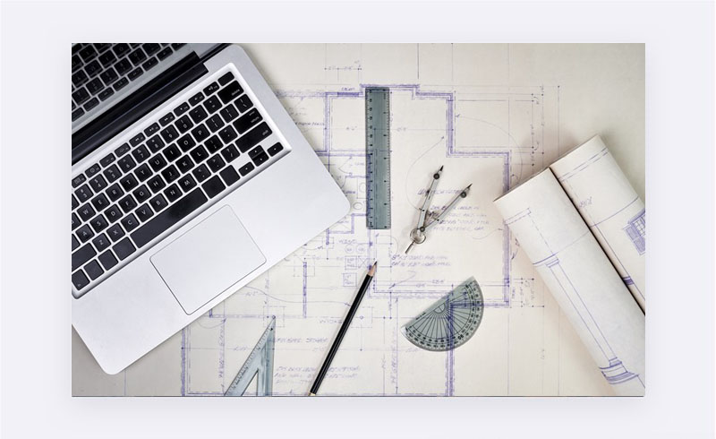 Laptop, projekt na papieri a geometrické pomôcky