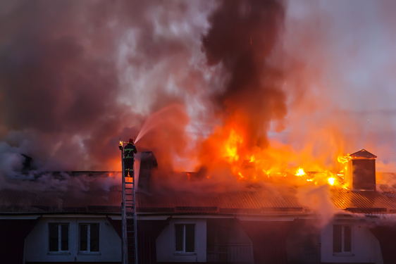 Imagine cu pompieri stingă flăcările de pe acoperișul unei case